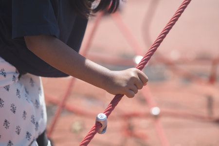 Child exploring climbing equipment at outdoor playgroundの写真素材