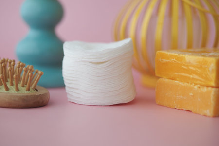 Cotton pads and natural soap on pastel background