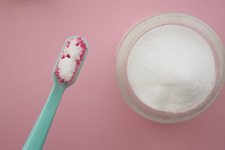Bright teal toothbrush ready for use with baking soda powderの写真素材