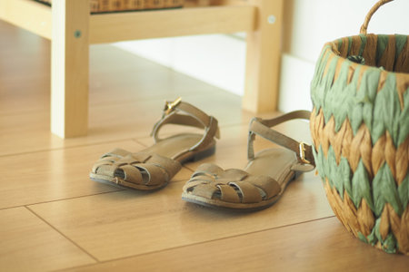 Footwear resting beside a woven basket on wooden floor