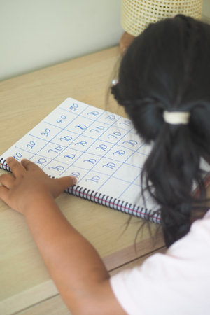 Child practicing numbers at a home learning tableの写真素材