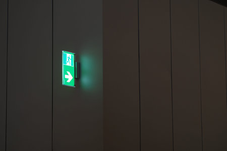 Lit emergency exit sign in modern corridor