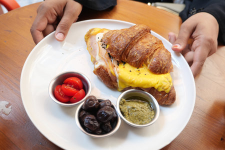 Croissant sandwich served with olives and cherry tomatoesの写真素材