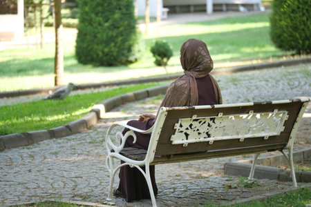 Woman sitting on a bench in a tranquil park settingの写真素材