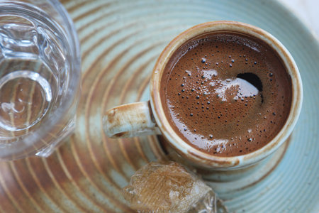 turkish cup of coffee on a ceramic plate by the waterの写真素材