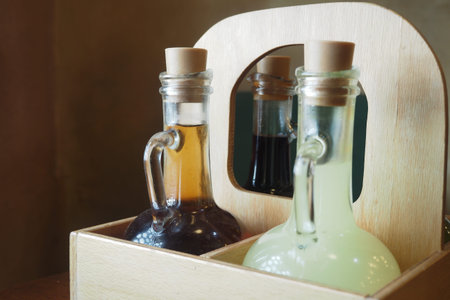 Condiments in glass bottles on wooden caddy in restaurantの写真素材