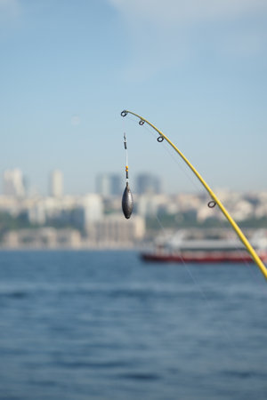 Fishing rod casting line over city water viewの写真素材
