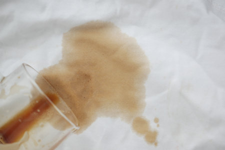 Coffee spills on a white kitchen clothの写真素材