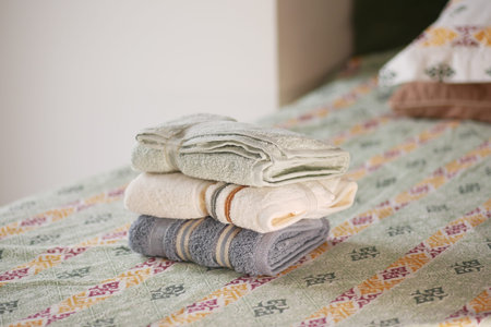 Soft towels neatly arranged on a patterned bedspread