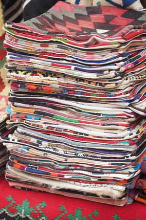 Colorful textiles stacked at a local market in the afternoonの写真素材