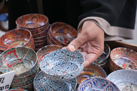 Colorful handmade bowls at a bustling market stallの写真素材