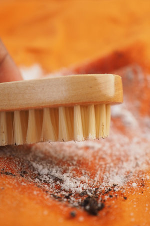 Cleaning a cloths with a brush and soda powder on fabric