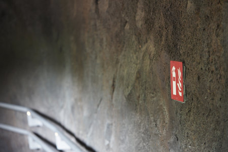 Fire Extinguisher Safety Sign on a Rustic Textured Concrete Wallの写真素材