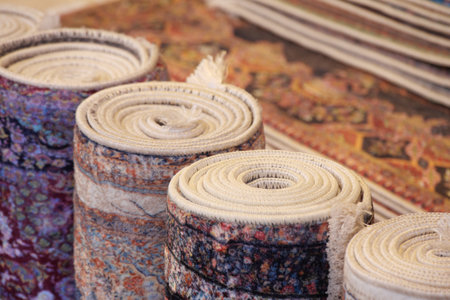 Colorful rolled rugs arranged in a traditional marketplaceの写真素材