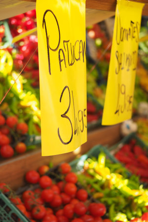 Colorful market stand showcasing fresh vegetables and pricesの写真素材