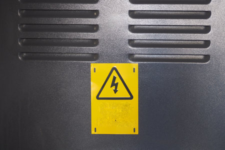 Warning sign indicating electrical hazard near equipmentの写真素材