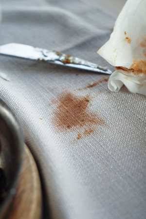 Dinner napkin stained with sauce on a table settingの写真素材