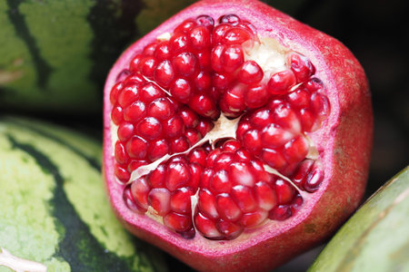 Fresh pomegranate cut open reveals juicy red seeds