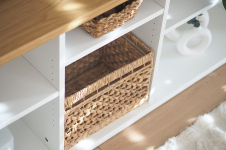 Woven baskets arranged neatly on modern white shelving unitの写真素材