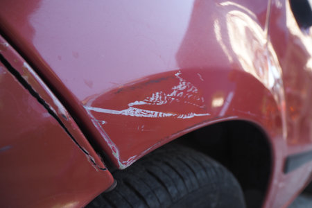 Car with visible scratches parked on the streetの写真素材