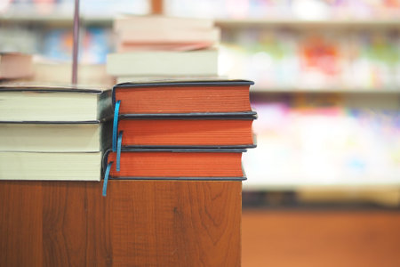 Colorful books stacked neatly on a wooden table in a library