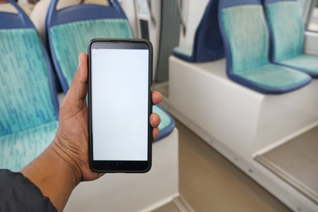 Holding a smartphone on a train journey in the afternoon