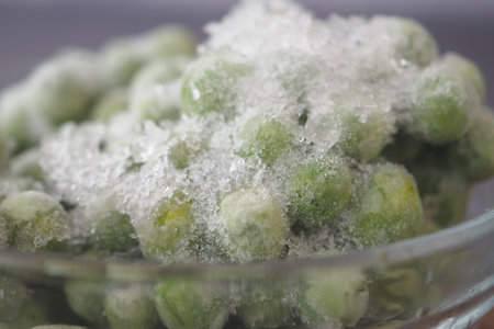 Frozen green peas in a glass bowl ready for cooking