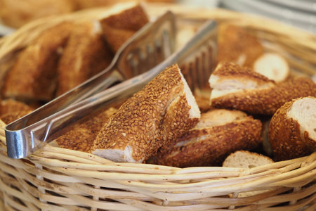 Freshly baked sesame bread rolls in a woven basket