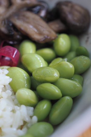 Delicious bowl of edamame, rice, and mushrooms in close-upの写真素材
