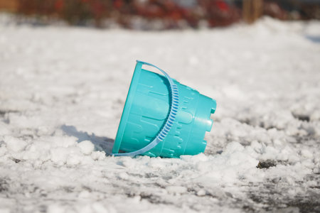 Blue bucket on snowy ground in a winter settingの写真素材