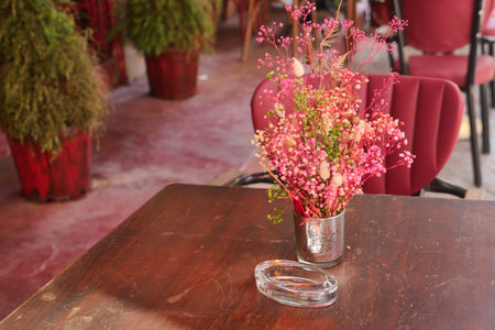 Colorful flowers in a vase at a cozy cafe tableの写真素材