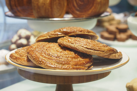 Flaky pastry with sesame seeds on a display stand