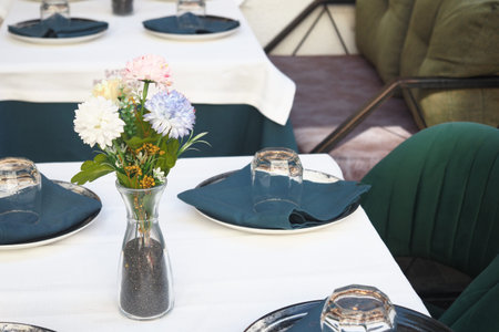Elegant table setup with flowers in a modern cafeの写真素材