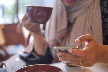Enjoying coffee while scrolling on the phone at a cafe