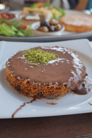 Delicious turkish kunefe on a plate with chocolate and nuts