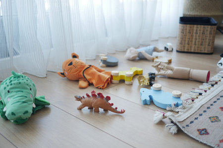 Colorful toys scattered on a wooden floor near a window