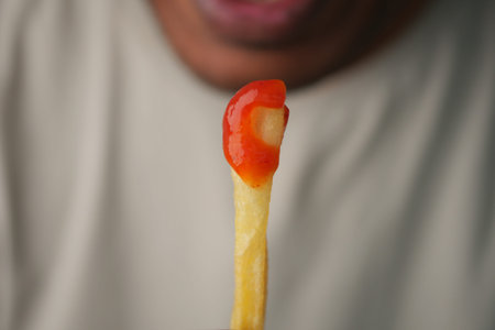 Eating a french fry with ketchup during a snack time
