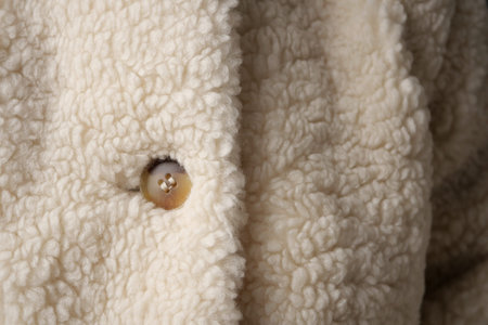 Soft cream fleece fabric close up with button detail