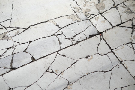 Cracked marble floor showing wear and age in indoor settingの写真素材
