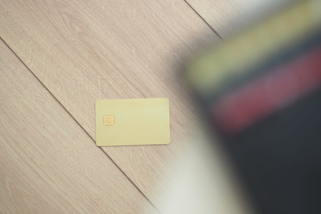 Yellow credit card accidentally dropped on wooden floorの写真素材