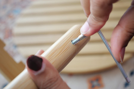 Screwing a bamboo furniture piece together in a workshop