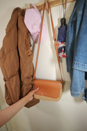 Stylish bag and accessories hanging on wall hook