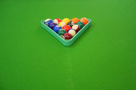 Billiard balls arranged in a triangle on green table