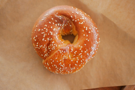 Freshly baked sesame bagel on parchment paper