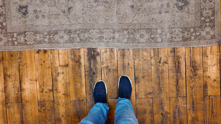 Footwear on wooden floor next to decorative rugの写真素材