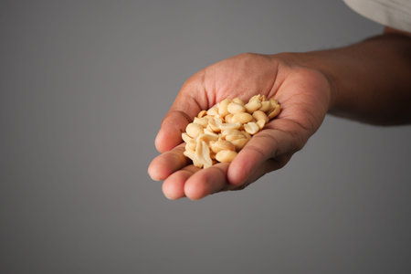 Hand holding a handful of light-colored seeds for planting