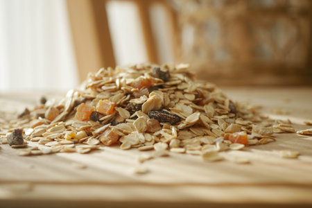 Piled oats with dried fruits on wooden tableの写真素材