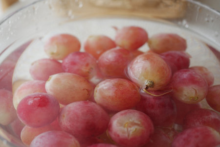 Fresh grapes soaking in water for cleaning and preparationの写真素材