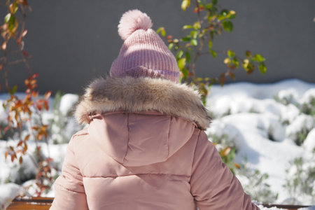Child enjoying a snowy day in winter parkの写真素材