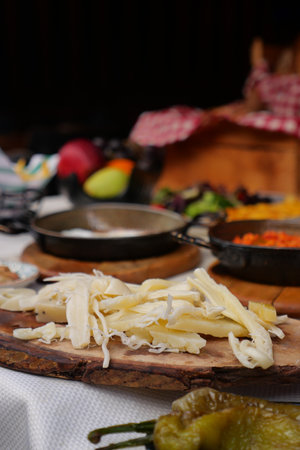 Fresh Shredded Cheese on Wooden Board With Pans and Pepperの写真素材
